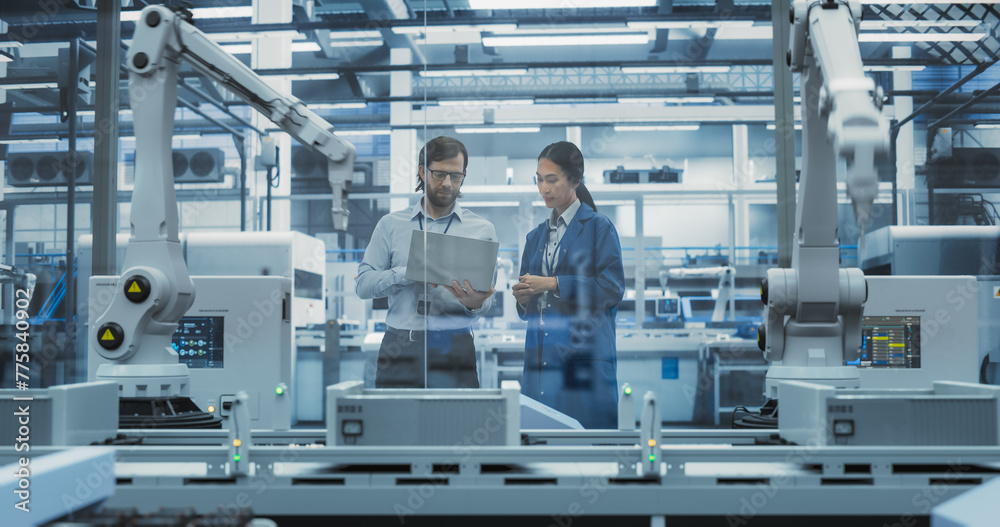 Poster Young Engineer and Asian Technician Having a Conversation and Using a Laptop Computer. Specialists Monitoring, Analyzing Conditions at a Modern Electronics Factory with Automated Assembly Line