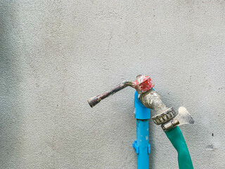 Water supply faucet on concrete or cement wall background with copy space.