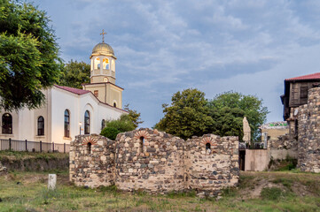 Fototapeta na wymiar ST. Cyril and Methodius Cathedral in Sozopol, Bulgaria. Rear view with ancient ruins of St. Nicola church.