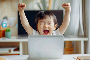 Happy Asian boy is using computer laptop, shouting and celebrating his victory. Child raises his hands up in success. Portrait of cheerful excited boy. Home distance learning at school through games