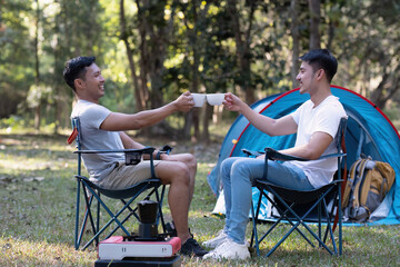 Obraz premium Young Asian homosexual couple spending their free time Holidays sitting together, relaxing, camping and hiking together.