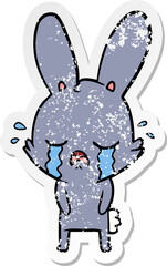 distressed sticker of a cute cartoon rabbit crying