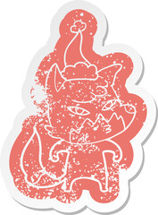 clever quirky cartoon distressed sticker of a fox wearing santa hat