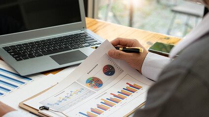 Business accounting concept Businessman uses calculator with laptop computer Budget and borrowed paper Calculate expenses, expenses, taxes online, manage company budgets, close-up images