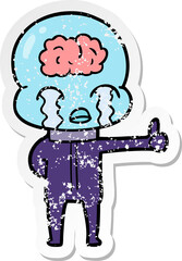 distressed sticker of a cartoon big brain alien crying but giving thumbs up symbol