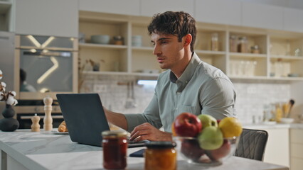 Businessman working kitchen table with laptop close up. Student studying online