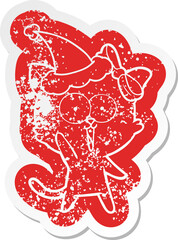 quirky cartoon distressed sticker of a cat wearing santa hat