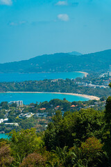 Fototapeta na wymiar Viewpoint of Karon Beach, Kata Beach and Kata Noi in Phuket, Thailand. The beautiful coastal basin and surrounding buildings are visible from a distance and the sky is blue from a high vantage point.