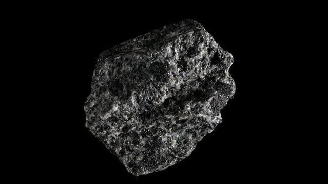 Augite (Silicate of calcium, magnesium, iron, titanium and aluminium) sample rotating slowly against a black background.