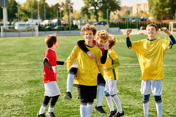 A group of young boys stand triumphantly on top of a carefully manicured soccer field, their faces...
