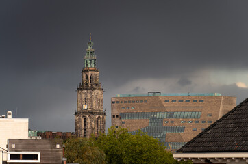 Fototapeta na wymiar The Martinitoren and the Forum building under a dark sky in the historical city centre of Groningen.