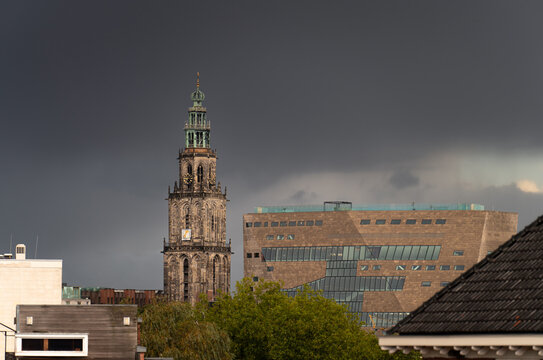The Martinitoren and the Forum building under a dark sky in the historical city centre of Groningen.