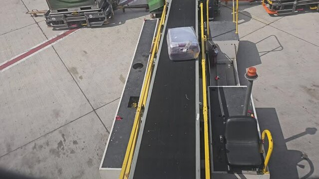 Loading luggage on the plane. The baggage on the conveyor belt to the airplane.