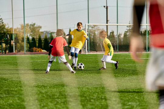 A group of young children, full of energy and enthusiasm, playing an intense game of soccer on a grassy field. They are kicking, running, and passing the ball, displaying teamwork and sportsmanship.