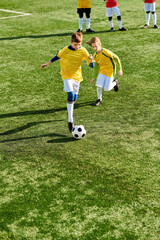 Obraz premium A vibrant scene unfolds as a group of young children play an enthusiastic game of soccer on a sunny field. They run, kick, and pass the ball, showcasing teamwork and camaraderie.
