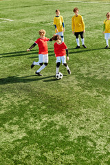 Obraz premium A group of young children energetically playing a game of soccer on a grassy field. They are running, dribbling, passing, and kicking the ball with enthusiasm and teamwork.