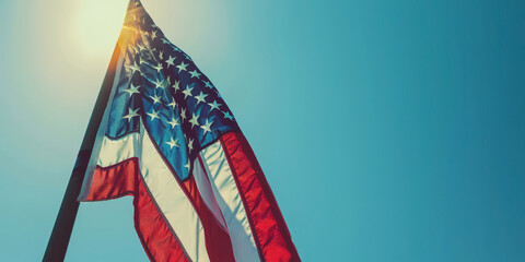 American flag waving against a clear blue sky. Banner with place for text.
