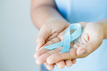 woman with blue ribbon for patients with breast and cervical cancer