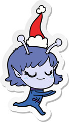 smiling alien girl hand drawn sticker cartoon of a running wearing santa hat