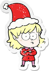 hand drawn distressed sticker cartoon of a elf girl staring wearing santa hat