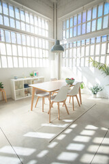 Interior design industrial loft with table, and chairs in a dining room. Sun trough the window. High quality photo