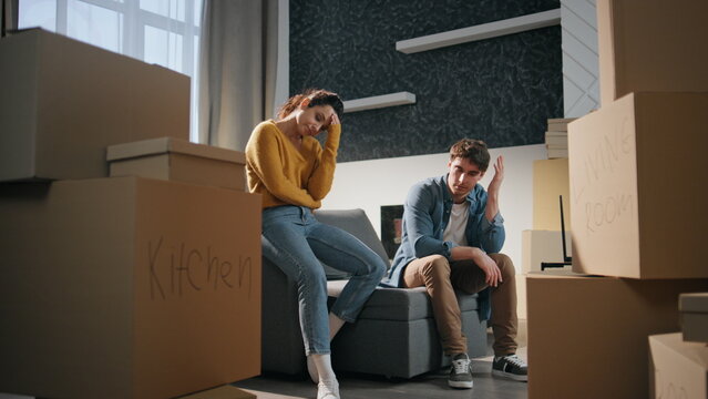 Exhausted spouses moving apartment. Tired married couple sitting couch new home.