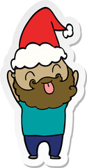 man with beard sticking out tongue wearing santa hat