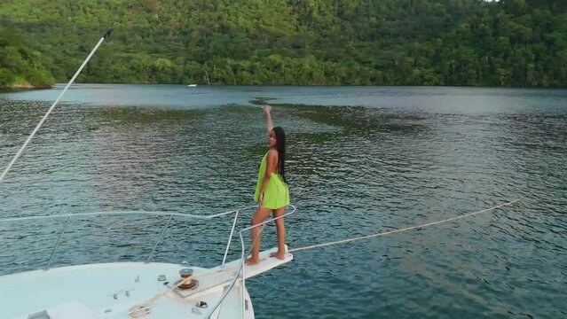On a yacht in the Caribbean, a young girl in beach attire is observed from an aerial drone's perspective.