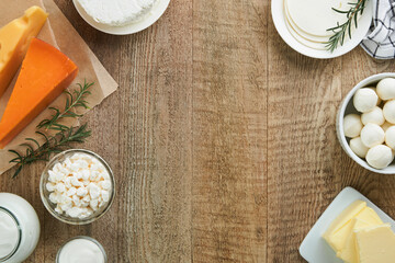 Dairy products or farm products. Fresh organic dairy products milk, cottage cheese, butter, cream, yogurt, sour cream and mozzarella on old wooden rustic background. Top view. - obrazy, fototapety, plakaty