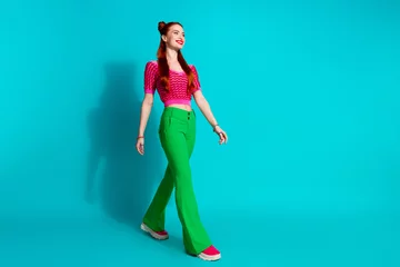 Foto op Aluminium Full length photo of funky adorable lady dressed pink knitted shirt walking emtpy space isolated blue color background © deagreez