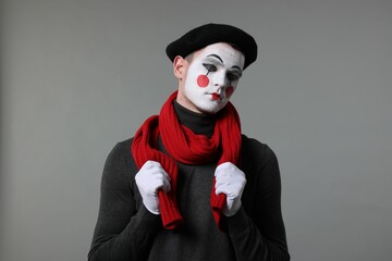 Portrait of mime artist in beret on grey background