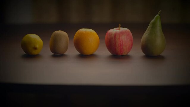 A row of fruits displayed on a wooden table in a still life photography setting