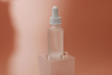 A mock-up of a beauty serum bottle in a pink background and a transparent platform