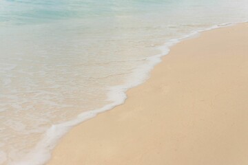 Fototapeta na wymiar Scenic shot of foamy waves crashing the sandy shore, cool for background