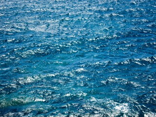 Rough blue water of the Atlantic Ocean sparkling in bright sunlight in