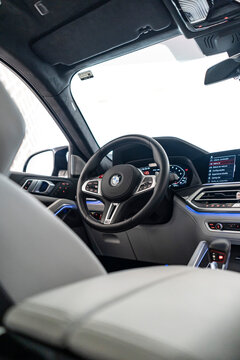 2024 BMW X6 M Competition steering wheel and dashboard view from rear seats, white and black leather interior - High Resolution Image