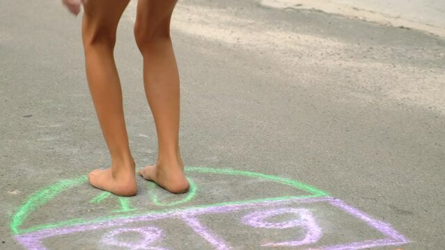 children play hopscotch on the street. selective focus.