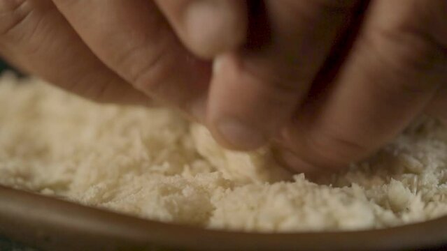 Cook assembling condensed milk ball with grated coconut