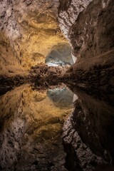 Fototapeta na wymiar Vertical shot of Mirror-like reflection in an underground lake in the Cave of the Greens, Lanzarote