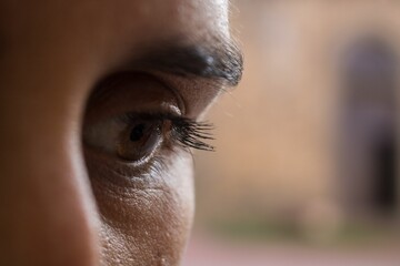 Close-up of a person's eye with long eyelashes and thick brows