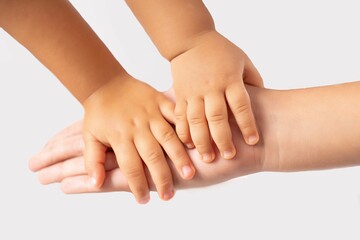 Mother holding the hands of her children on a white background - the concept of care