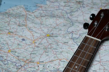 High-angle shot of a guitar put on the map of Poland - concept of traveling