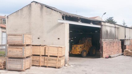 Tractor en almacén con cajas de madera
