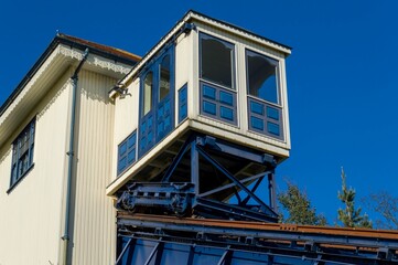 Low angle shot of blue and white cargo lift by a building against blue sky