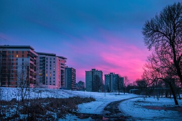 Beautiful shot of a bright pink blue sunset sky over a  residential area in downtown Kielce, Poland
