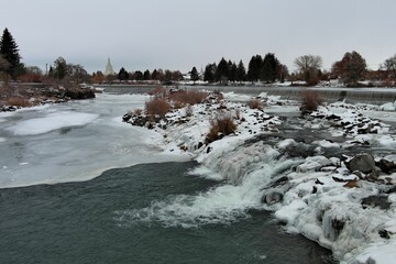 Aerial shot of the frozen river and field covered with trees, Idaho falls, USA