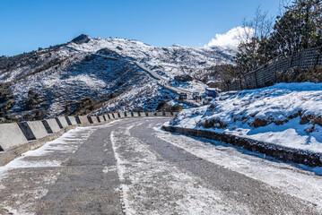 Mountain trail leading to the snow-covered mount peak in a snowy landscape