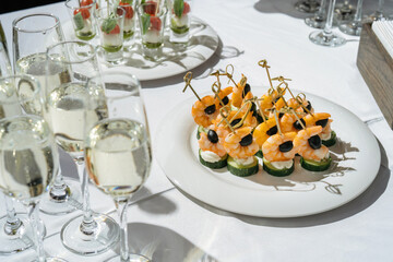 Champagne glasses on the table. shrimp and olives for appetizer.