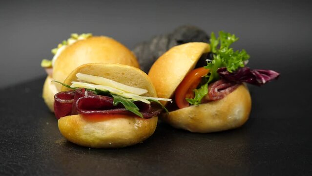 Panini gourmet ripieni con bresaola, rughetta, formaggio e insalata.
Vassoio con panini per l'aperitivo farciti con prosciutto e parmigiano.