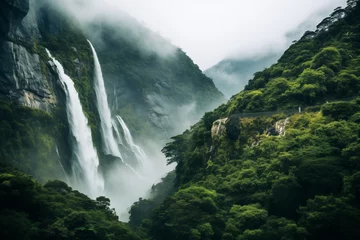 Fotobehang A majestic waterfall cascading down a lush green mountainside, surrounded by vibrant foliage and misty air © The Origin 33